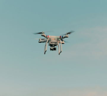 white and black drone flying in the sky